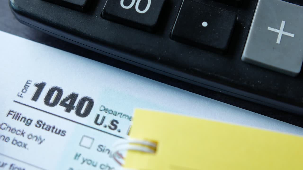 Tax Form 1040 with Calculator and Writing Utensils