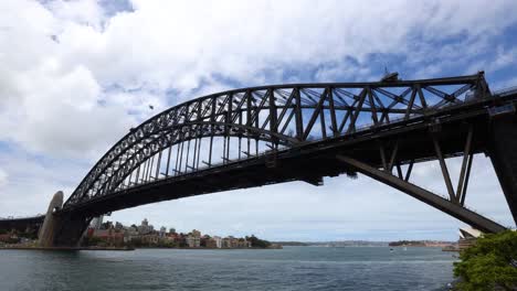 Wide-angle timelapse of the Sydney Harbour Bridge during the daytime with boats passing through.