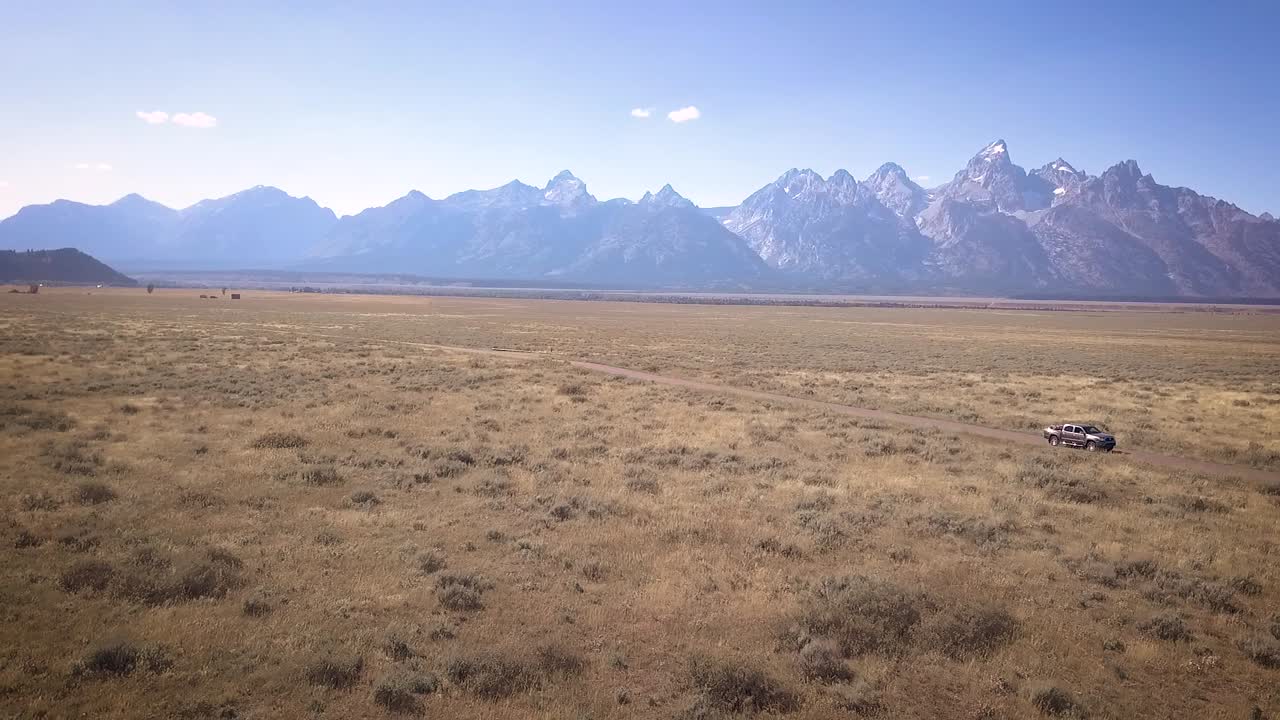 toma de drones del parque nacional grand teton con los tetons visibles y las praderas brillantes debajo