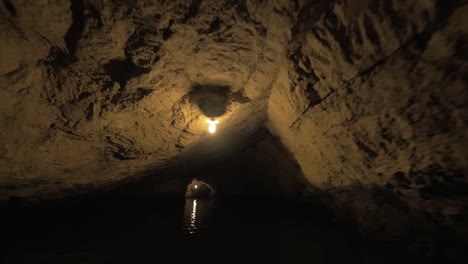 Excursión-En-Barco-A-Través-Del-Oscuro-Sistema-De-Cuevas,-La-Misteriosa-Atmósfera-De-La-Naturaleza-De-Vietnam.