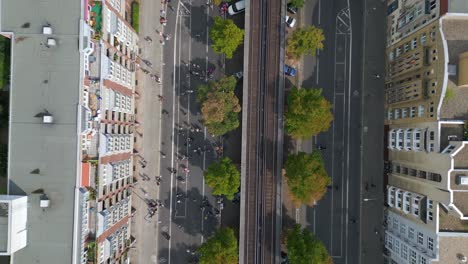 suburban-railroad,-Magic-aerial-top-view-flight-CSD-Pride-Love-Parade-2023-in-city-Berlin-Germany-Summer-day