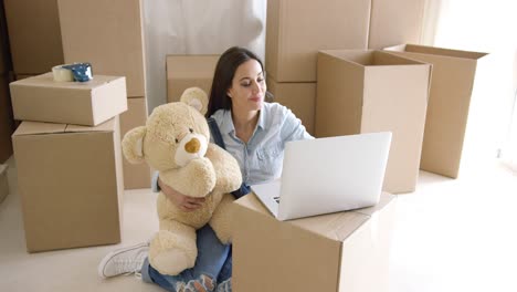 Young-woman-moving-house-with-her-teddy-bear