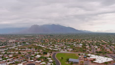 Aufschlussreiche-Drohnenaufnahme-Von-Tucson-Arizona-Mit-Leichter-Wolkendecke-Und-Bergen-In-Der-Ferne