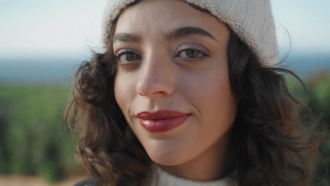 pretty tourist posing outdoors in knitted hat closeup. cheerful girl enjoying