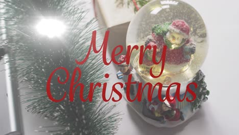 Animation-of-merry-christmas-text-over-snow-globe