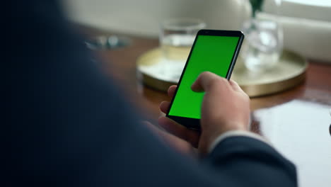 Mann-Scrollt-Mit-Der-Hand-über-Den-Grünen-Smartphone-Bildschirm,-Nahaufnahme.-Geschäftsmann-Mit-Chroma-Key