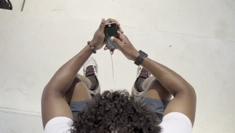 Top-view-of-African-American-man-using-modern-phone-outdoor.