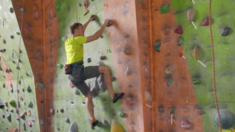 Climbing-sport-activity-concept:-Man-climber-on-wall.-Indoor-climbing-sport-activity-concept:-man-climber-on-artificial-climbing-wall.