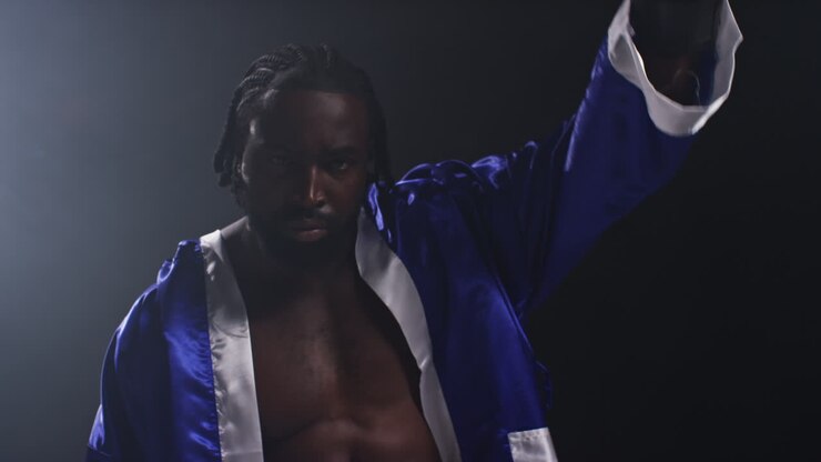 Portrait Of Boxer Entering Ring Before Start Of Boxing Match Waving And Greeting Fans Hitting Gloves Together With Low Key Lighting