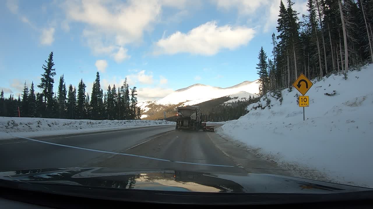 Time lapse di guida dietro uno spazzaneve nelle montagne del Colorado in una limpida giornata invernale di sole.