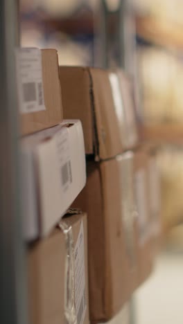 vertical video employee using barcode scanner on cardboard boxes in fulfillment center