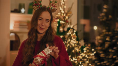 Woman-with-Christmas-gift-standing-in-living-room