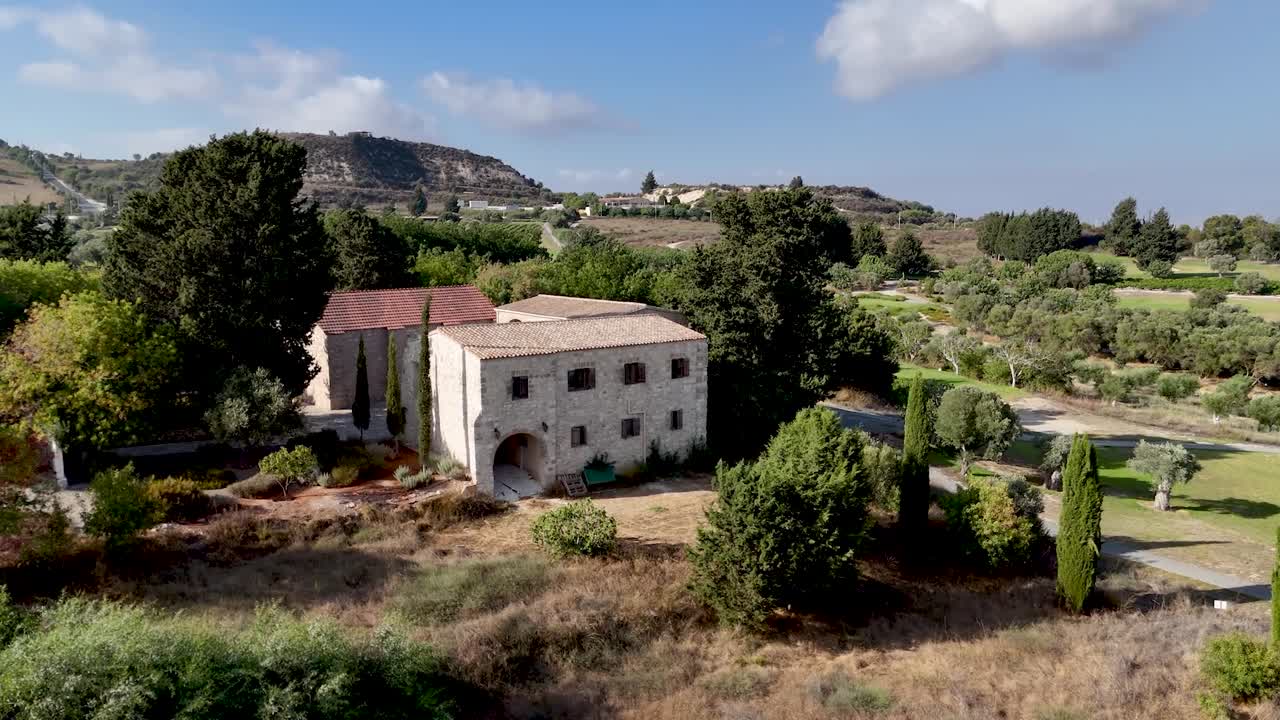Una splendida casa storica in pietra si trova nella rigogliosa campagna del sud della Francia. Ulivi e campi verdi circondano la proprietà, creando un'atmosfera di pace sotto un cielo azzurro.