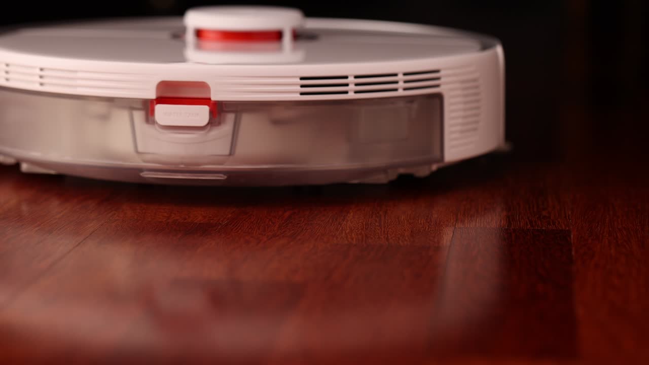 나무 바닥에 리더를 가진 스마트 로 진공청소기 로 진소기는 아파트의 자동 청소를 수행합니다. 느린 동작 100fps.