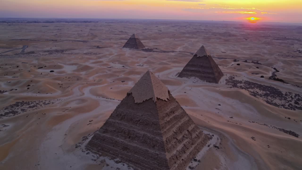 Aerial video captures pyramids at sunset, showcasing their grandeur against a vast desert landscape
