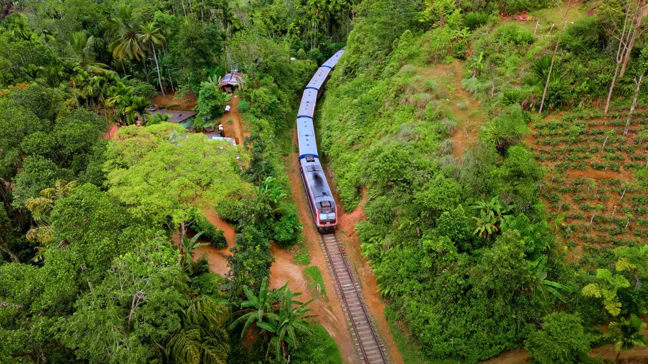 Captivating aerial drone footage of a train crossing the iconic railway bridge in Ella, Sri Lanka.