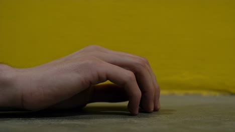 hand against a yellow background