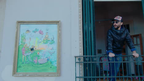 artist standing on a balcony and viewing city street