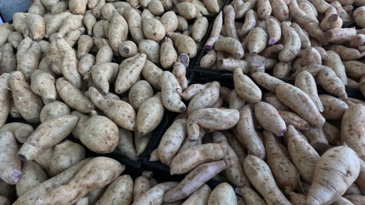 un montón de patatas dulces en un mercado