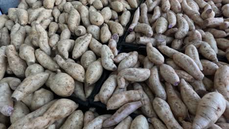 a pile of sweet potatoes at a market