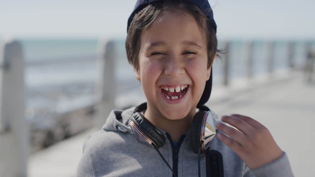 portrait of young little boy laughing cheerful  enjoying summer day on vacation seaside beach wearing hat