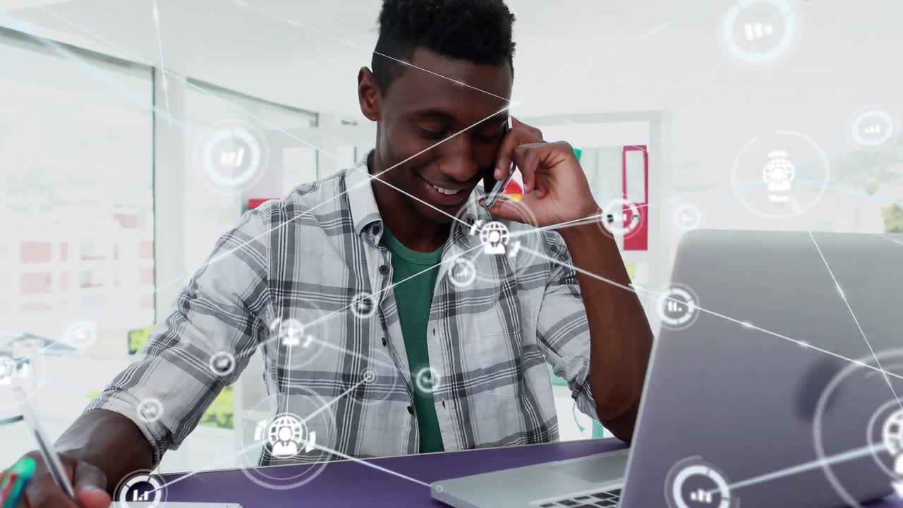 Animation of network of digital icons over african american man talking on smartphone at office
