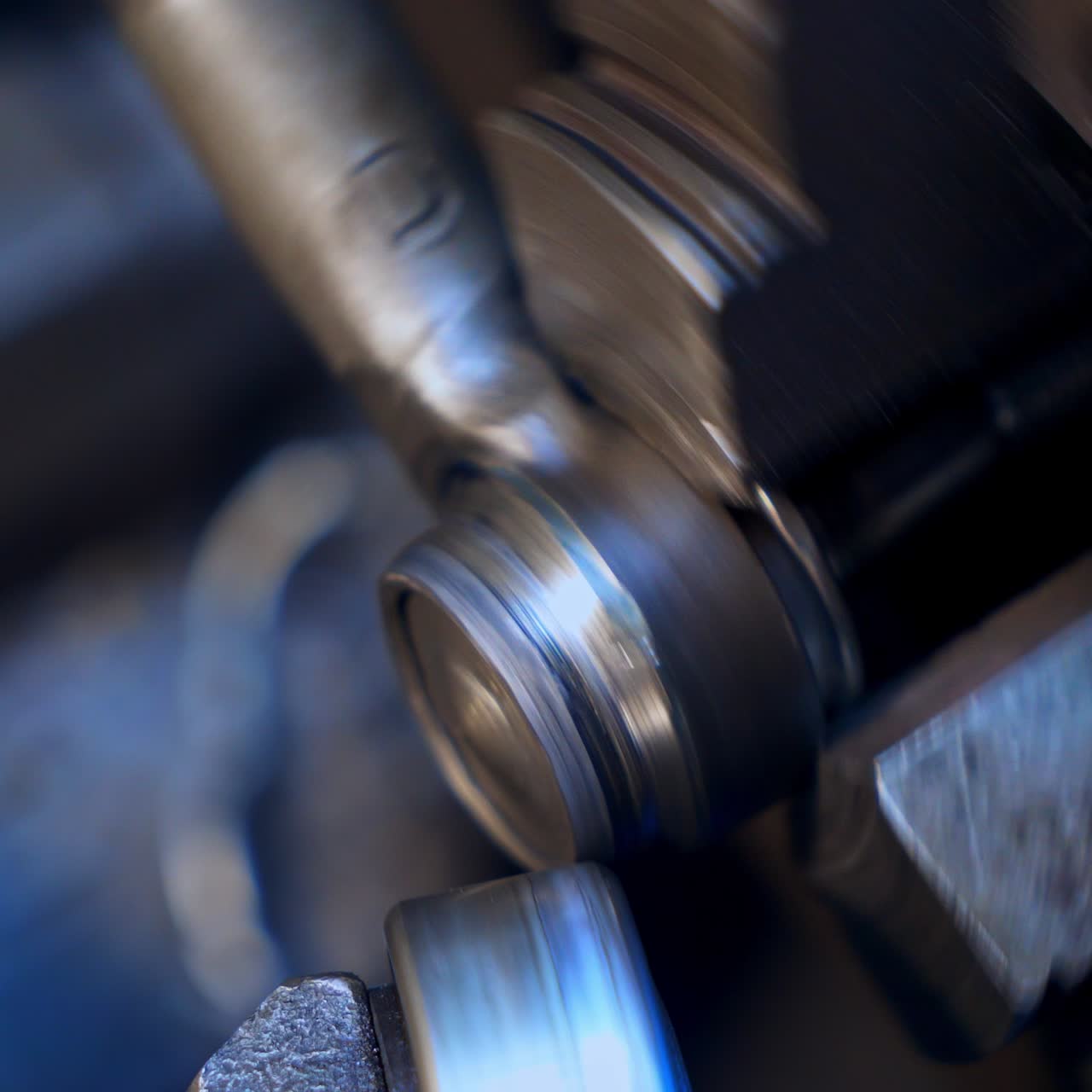 Two attached machine pieces turning to make screw-thread on the detail. Rotating mechanism on the turner's equipment. Close up