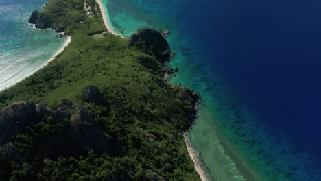 view of the popular island in fiji composed of glorious trees surrounded by blue calm ocean - aerial shot