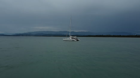 A-sailboat-rests-in-Costa-Rica's-calm-waters-beneath-an-overcast-sky.