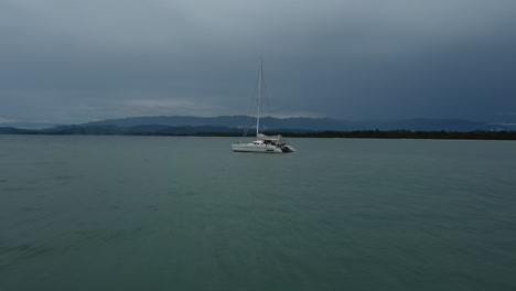 un velero descansa en las aguas tranquilas de costa rica bajo un cielo nublado.