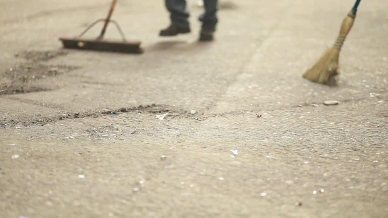 딱딱한 바닥에 먼지를 쓸고 있는 빗자루의 추상 샷