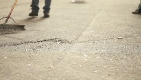 toma abstracta de escobas barriendo el polvo en un piso duro