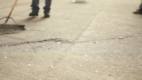 abstract shot of brooms sweeping dust on a hard floor