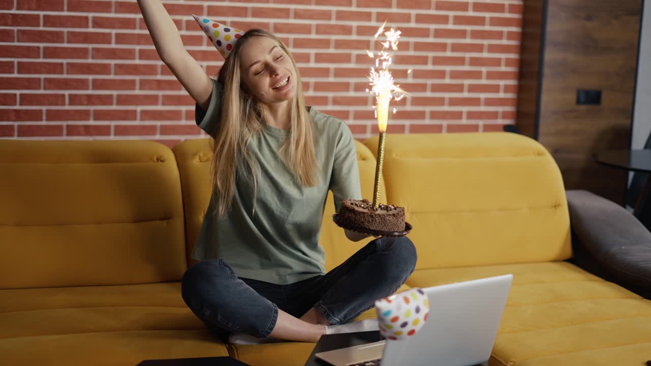 Mulher animada celebrando aniversário à distância online com amigos por videochamada.
