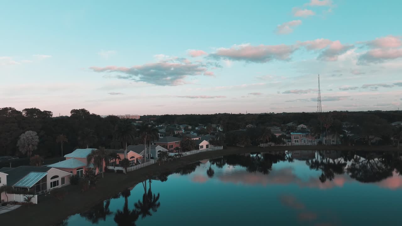 Jævne luftoptagelser over søen i boligområdet Winston Park i Florida, der fremhæver det rolige vand, forstadshusene og lokalsamfundets layout, optaget i klart dagslys med en filmisk dronebevægelse