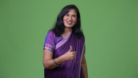 mature happy beautiful indian woman giving thumbs up while wearing sari traditional clothes