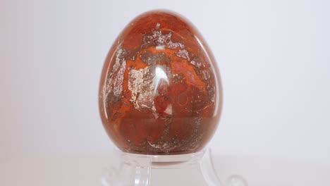 red earthly jasper mineral egg slowly rotating on a turn table