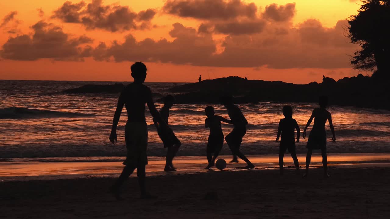 해가 지면 해변에서 놀고 있는 아이들