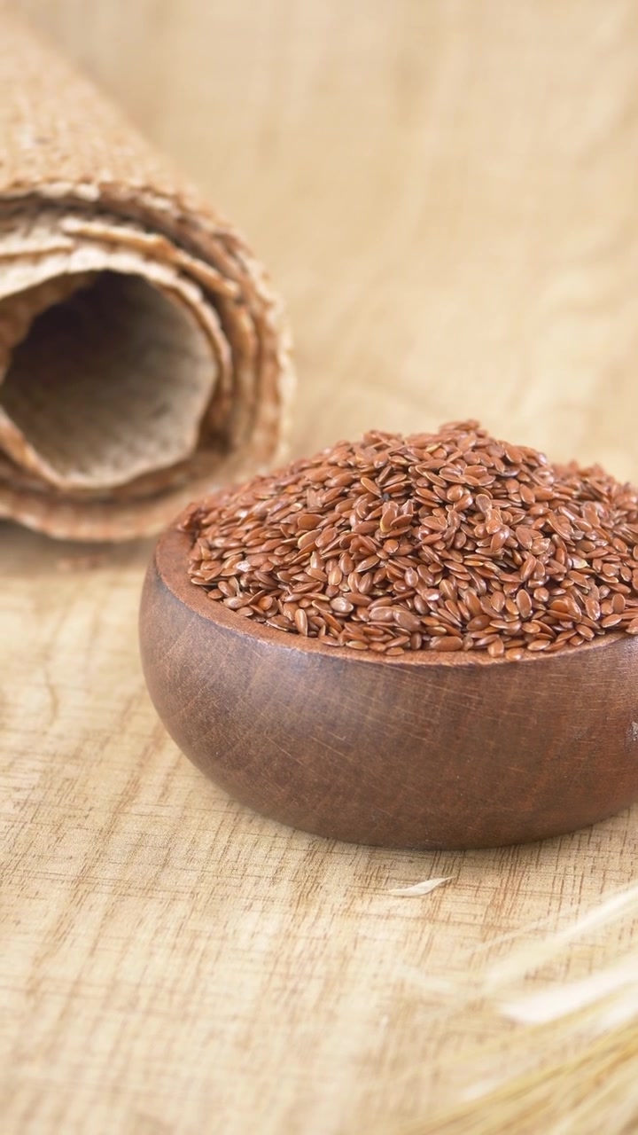 Flax Seeds in a Wooden Bowl on a Rustic Background