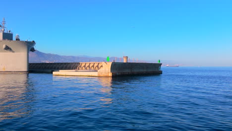 military ship docked at a floating dock