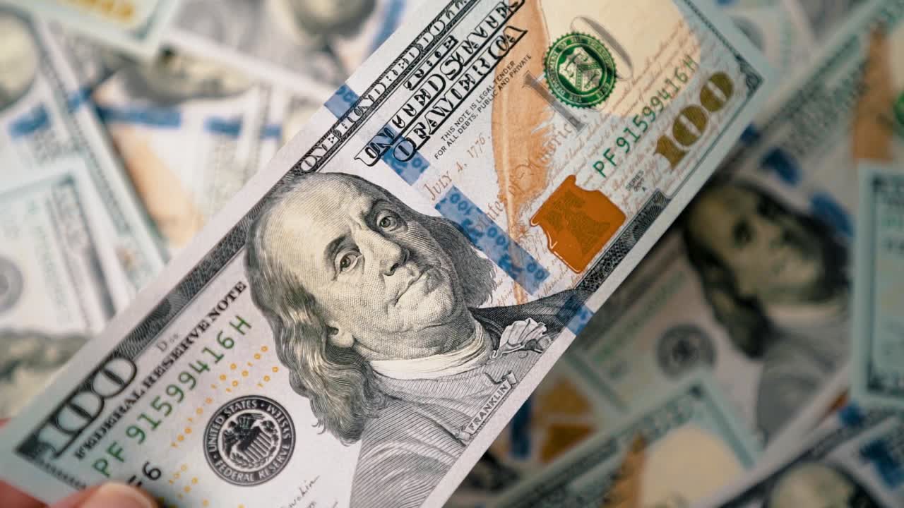 poniendo un billete de cien dólares encima de una pastilla dispersa en cámara lenta, siguiendo el siguiente disparo