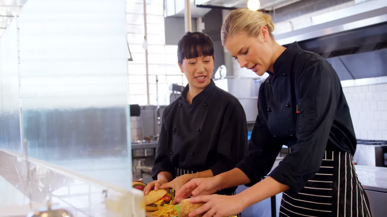 商用キッチン4kでハンバーガーを準備するシェフ