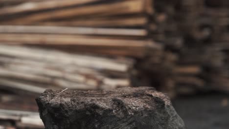 close-up of an ax chopping a wooden log that flies in different directions