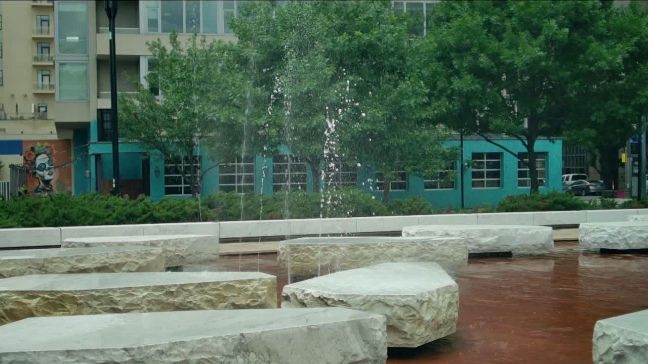 이 비디오 는 여러 개의 물줄기 가 시내 의 공원 에서 공기 에 뿌려지는 것 을 보여준다
