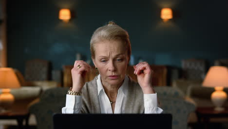 Senior-woman-arguing-during-video-call-on-laptop-computer-in-luxury-home