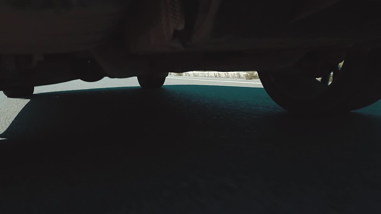 el coche se mueve a lo largo de la carretera la vista desde la parte inferior del coche