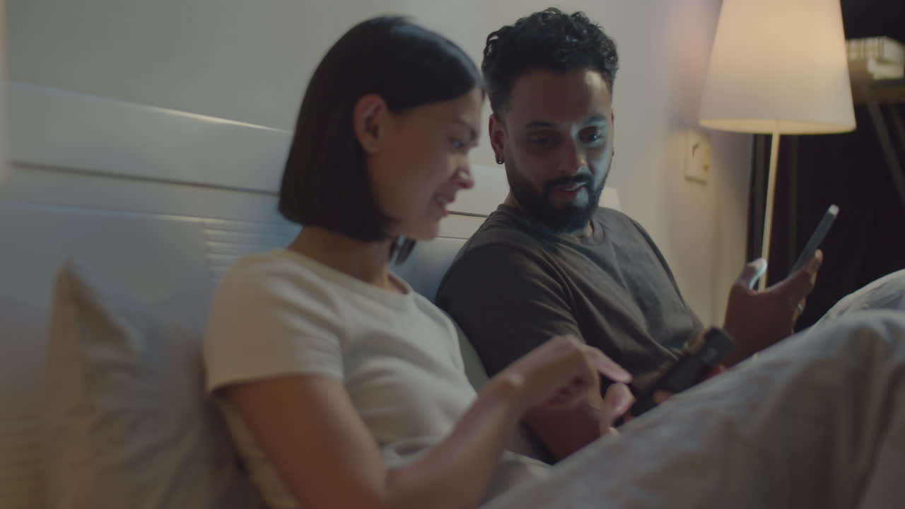 Couple Using Smartphone and Talking before Bedtime