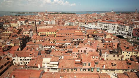 Luftdrohne-über-Der-Stadtarchitektur-Von-Venedig,-Italien,-Traditionellen-Häusern-Und-Gebäuden,-Romantischem-Klassischen-Stil,-Meeresküstenhorizont-Bei-Warmem-Tageswetter