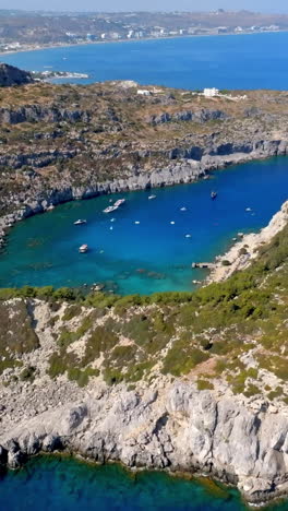 vertical drone shot backwards over the anthony quinn bay, in sunny rhodes, greece