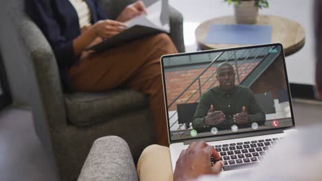 african american businessman using laptop for video call with african american business colleague